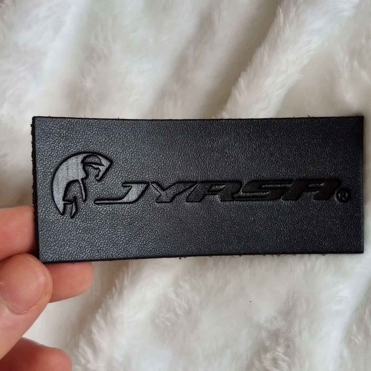 Custom debossed logo on a PU faux leather patch for hats