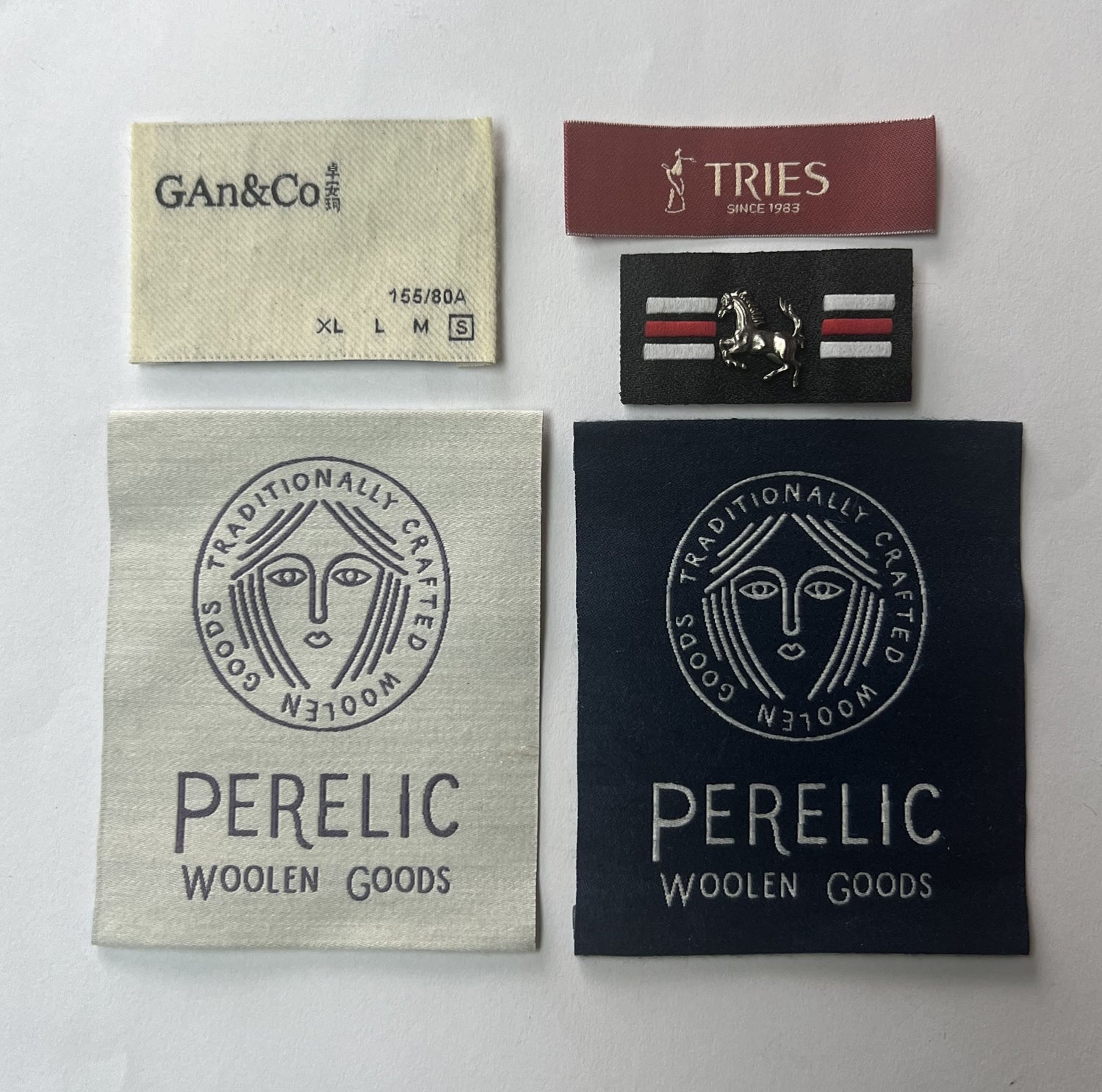A close-up of a custom high-definition damask woven label with a center fold, ready to be sewn into a t-shirt.