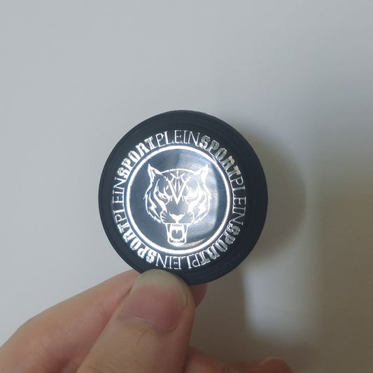 Custom black PVC badge with an embedded silver metallic logo.